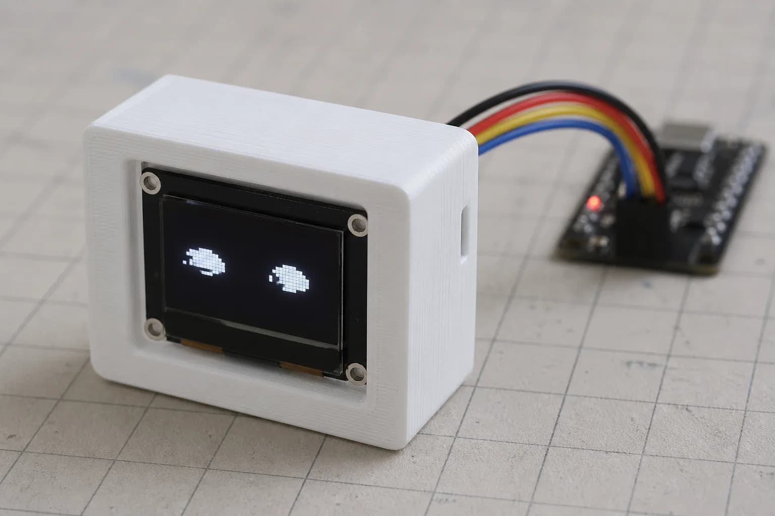 Original OLED prototype displaying a simple face during firmware experiments