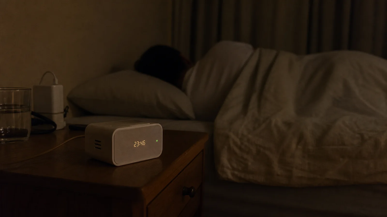 Đồng hồ chỉ báo giấc ngủ không có camera đặt trên tủ đầu giường, màn hình rất tối khi có người đang ngủ.