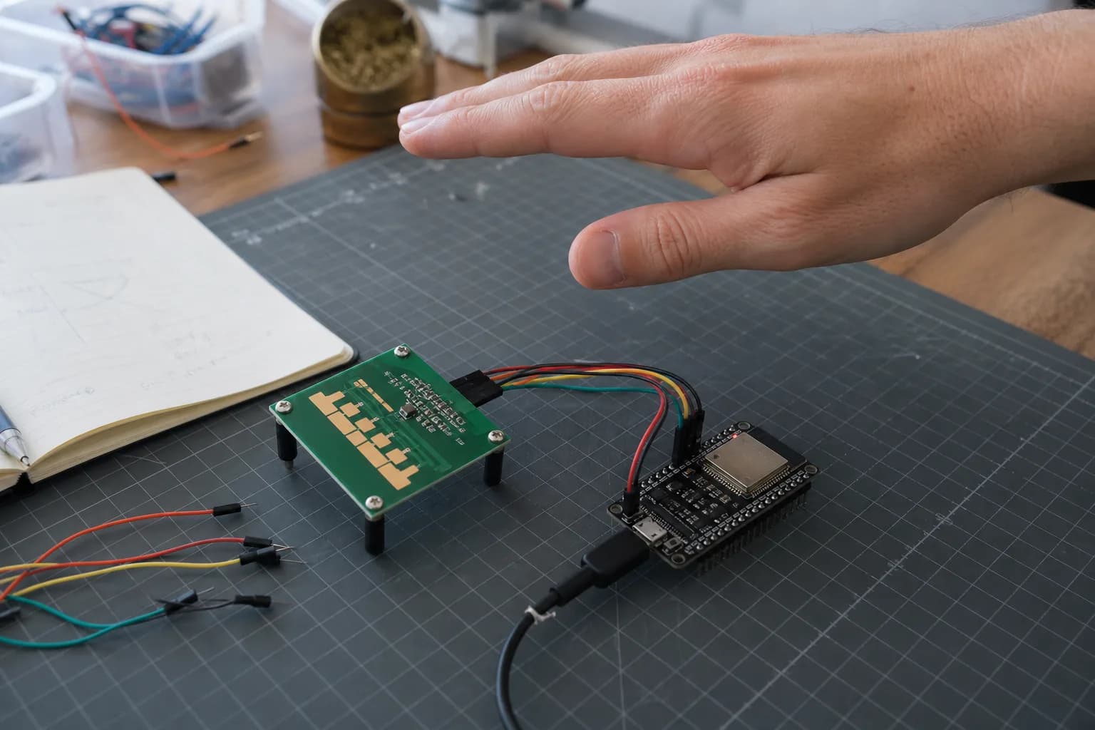 A maker tests an unbranded millimeter-wave radar module connected to an ESP32 on an electronics workbench